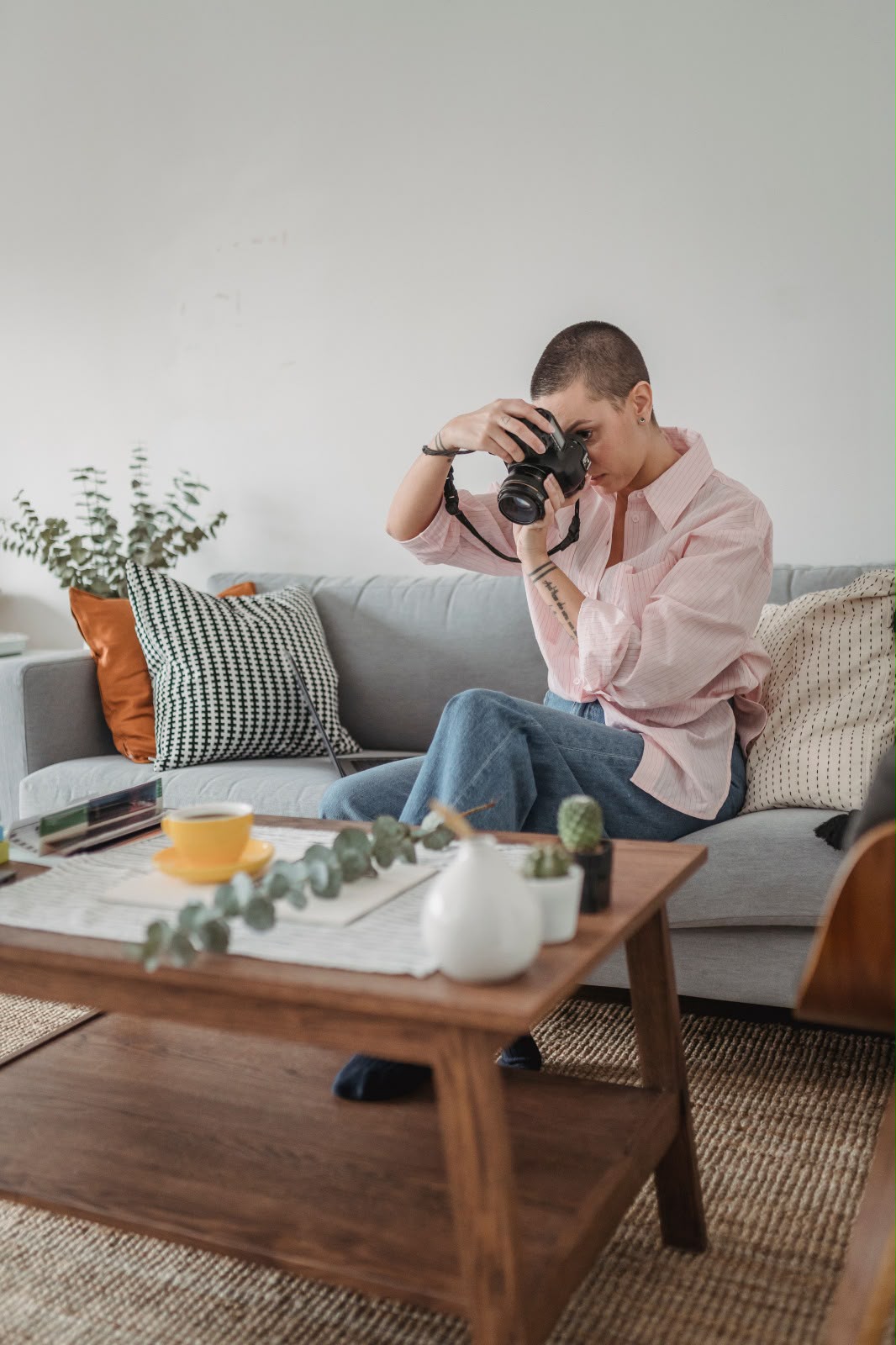 Fotógrafa profesional con cámara en un salón, imagen aportada para la colaboración inmobiliaria
