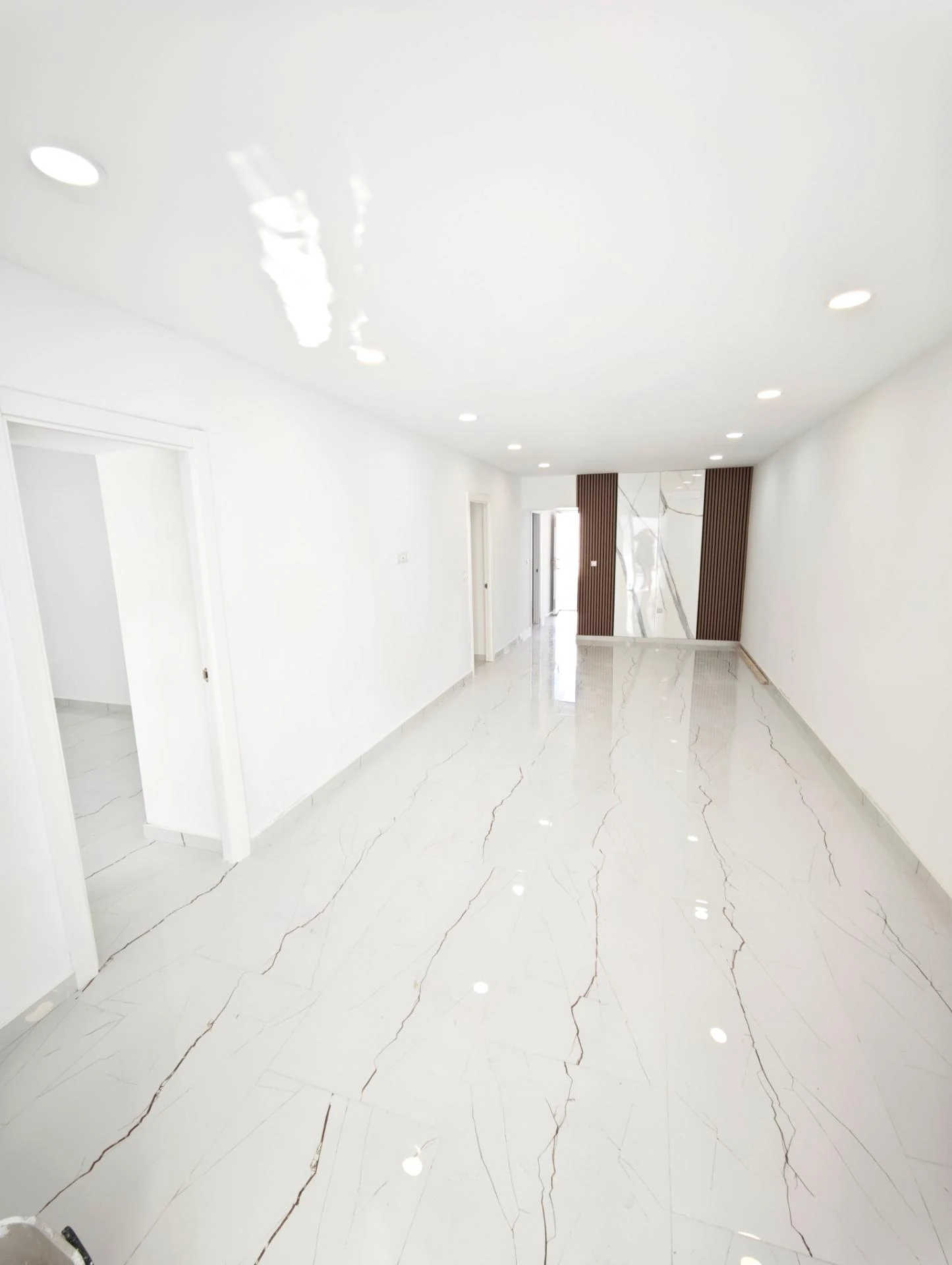 Salón diáfano con suelo de mármol tras la reforma integral