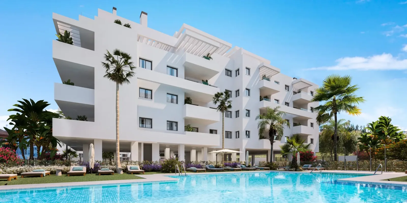 Fachada de la promoción con piscina comunitaria y palmeras