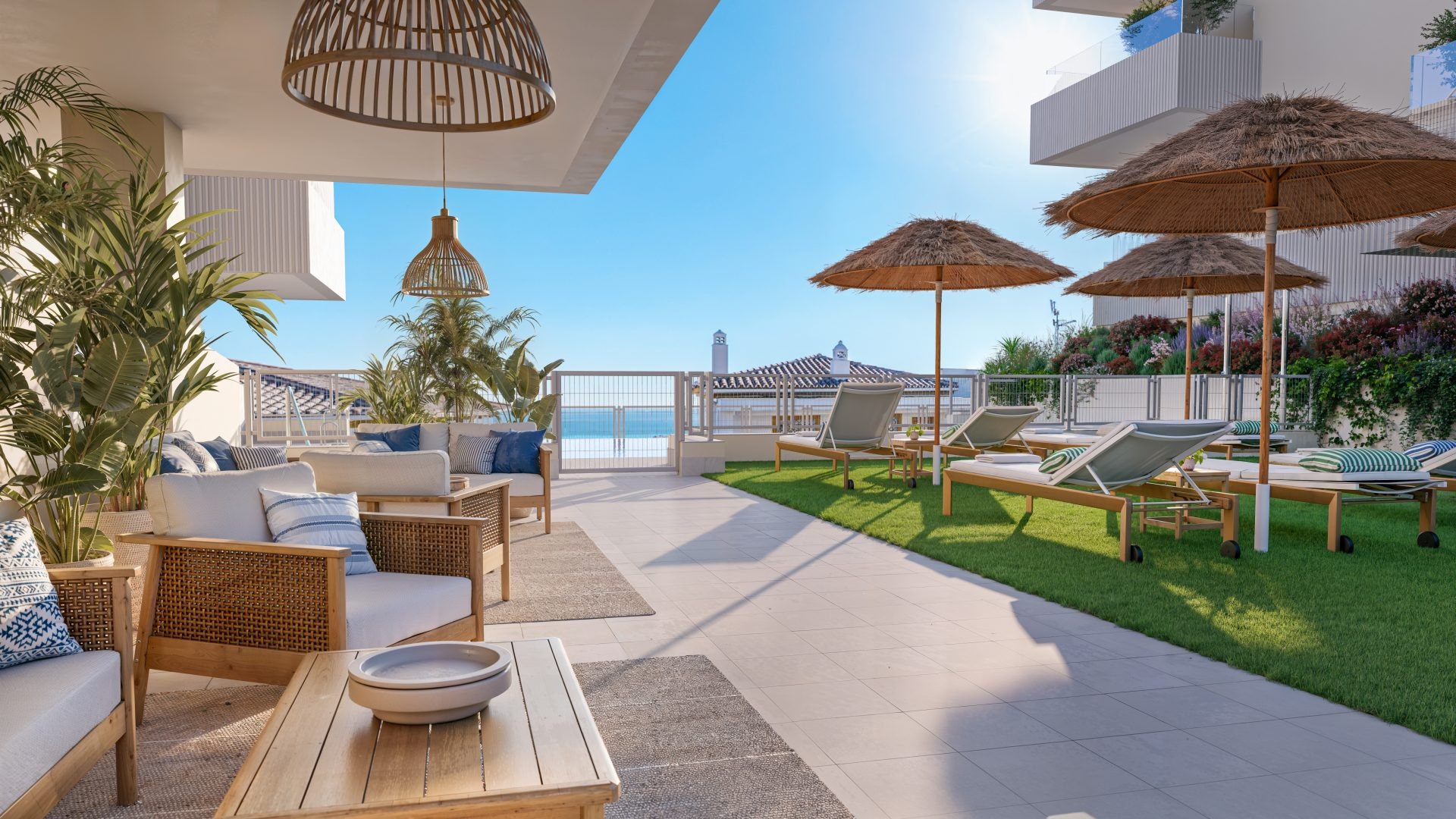 Terraza comunitaria con tumbonas, sombrillas de paja y vistas al Mediterráneo en Benalmádena