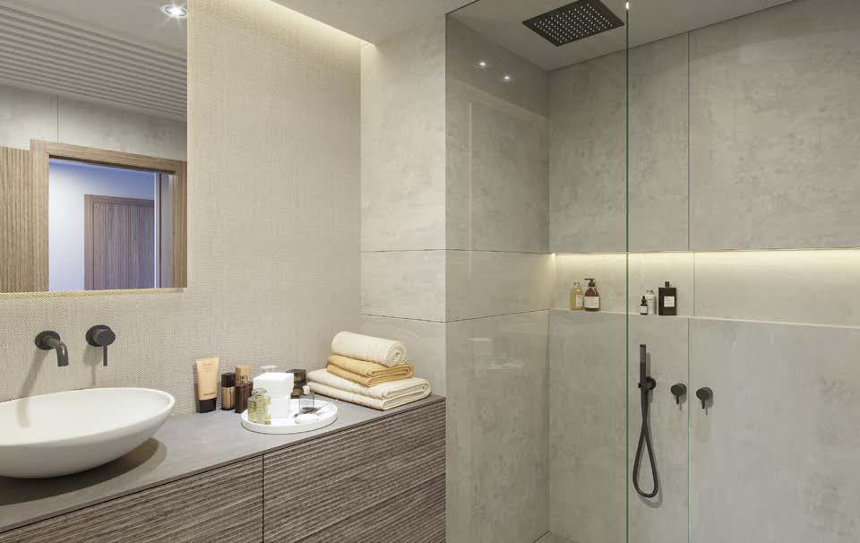 Baño en suite con ducha efecto lluvia y tonos piedra
