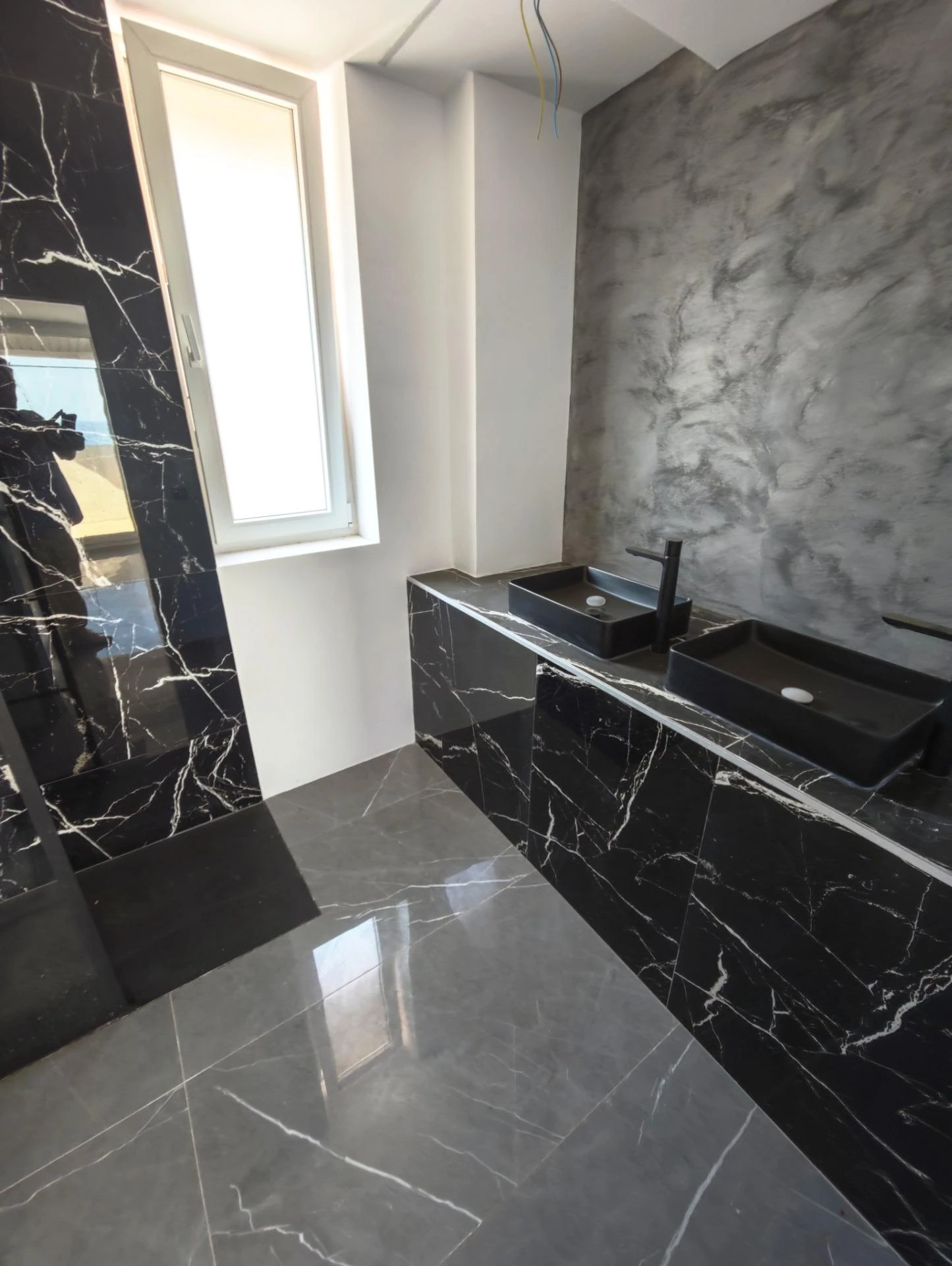 Baño secundario con mármol y luz natural