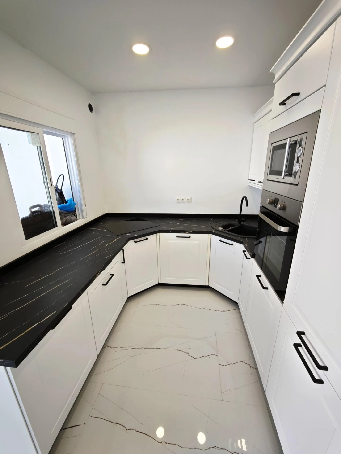 Cocina con muebles blancos y luz natural