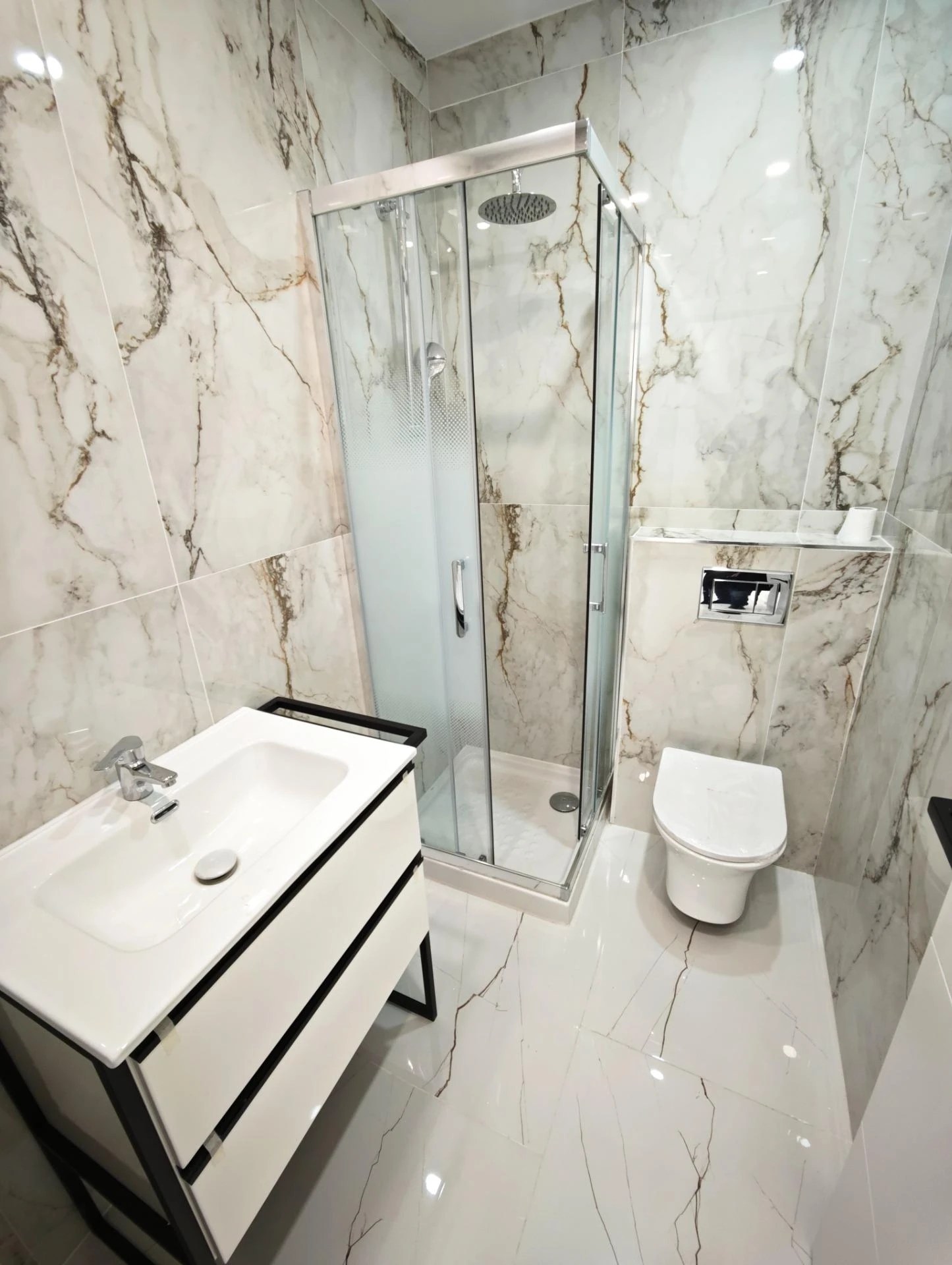 Baño en suite con mármol y ducha de obra