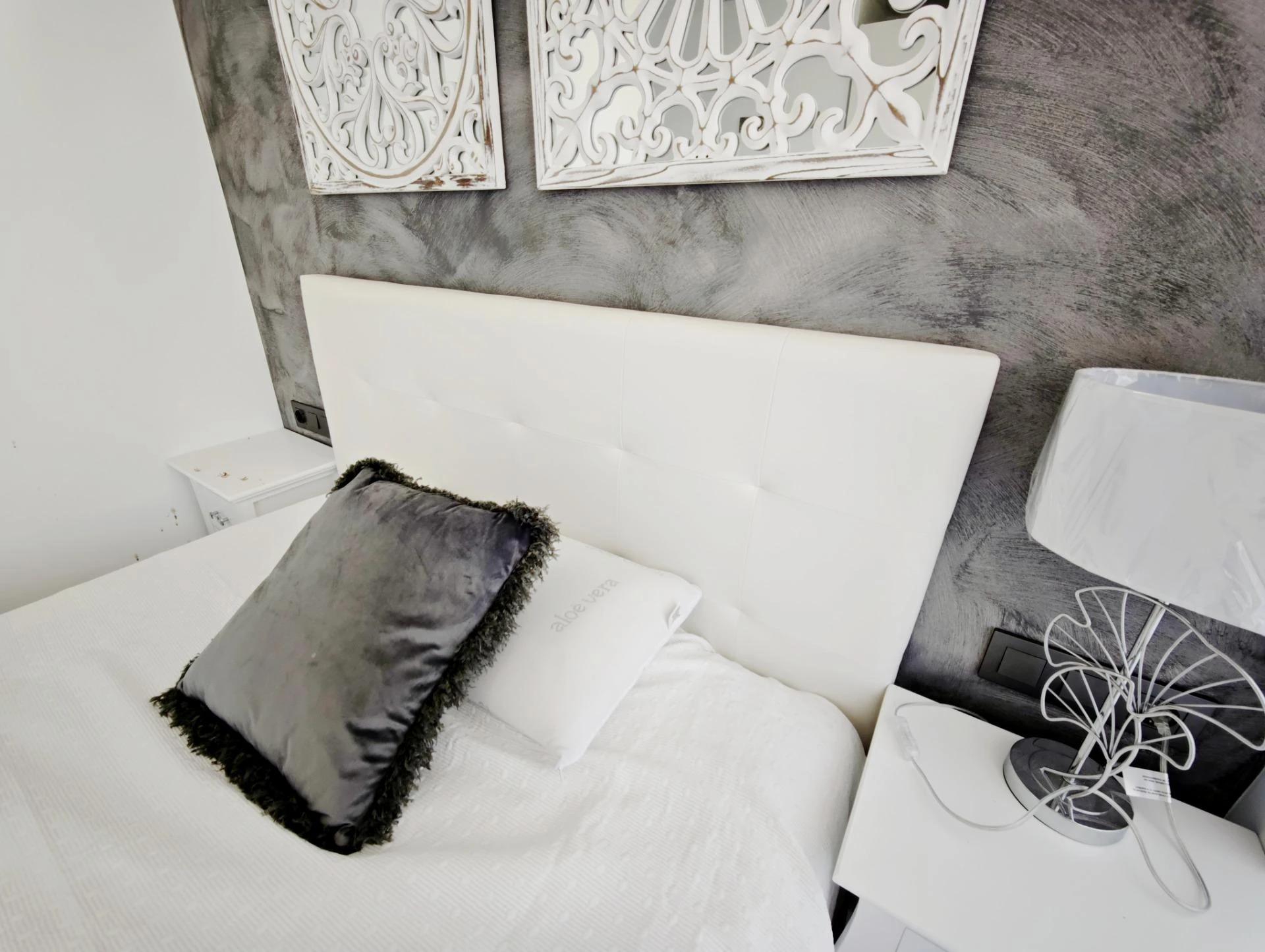 Dormitorio con cabecero de microcemento y luz natural