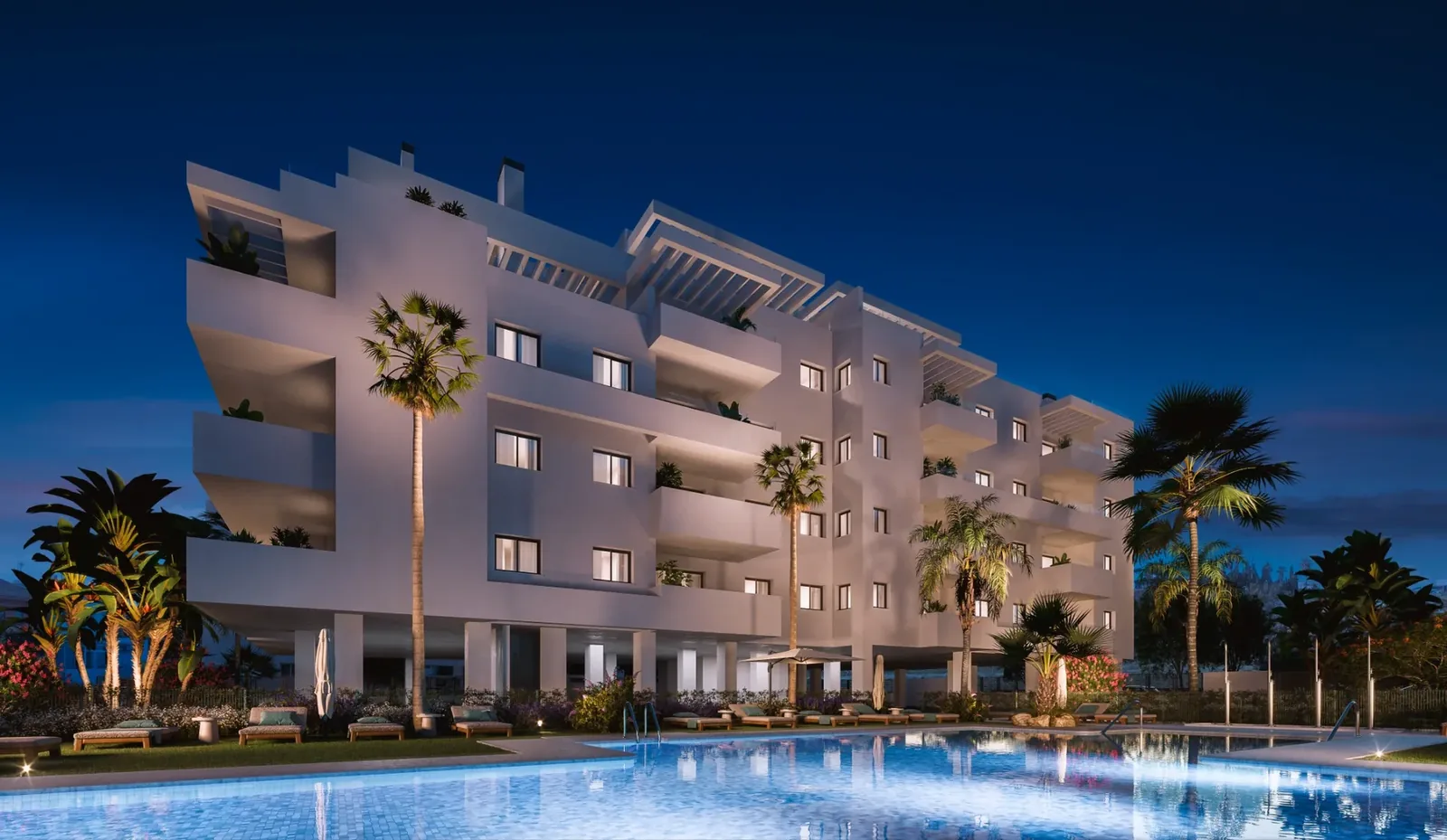 Fachada y piscina iluminadas al anochecer
