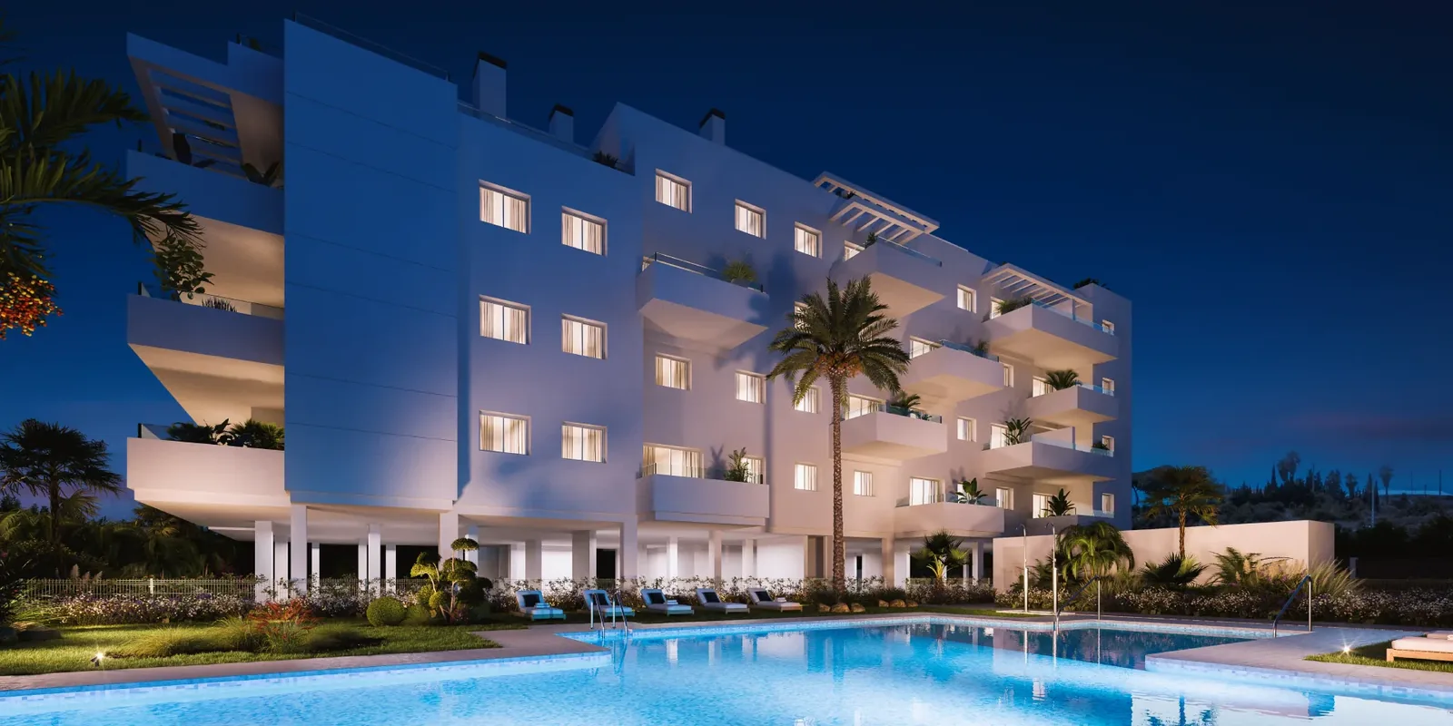 Piscina y fachada iluminadas al anochecer