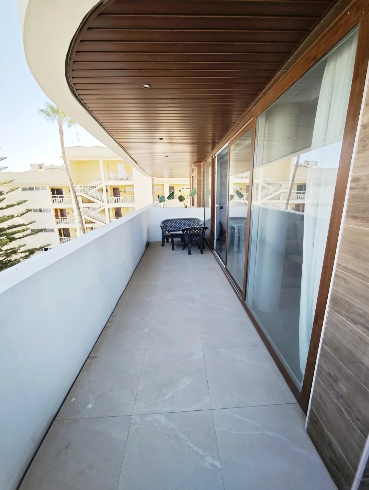 Terraza corrida con techo de madera y salida desde todas las estancias